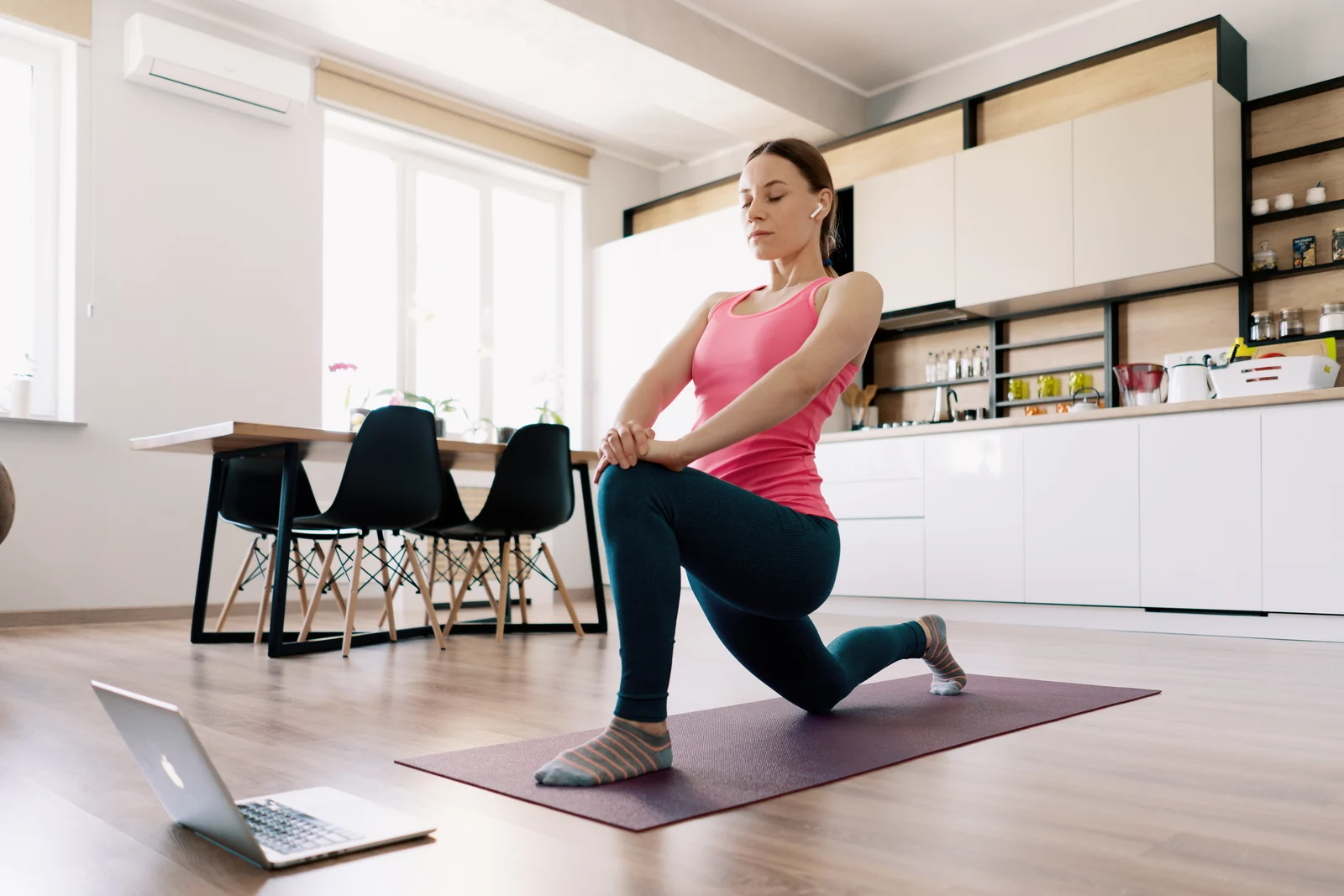 Personne faisant une séance de sport à domicile devant un ordinateur portable