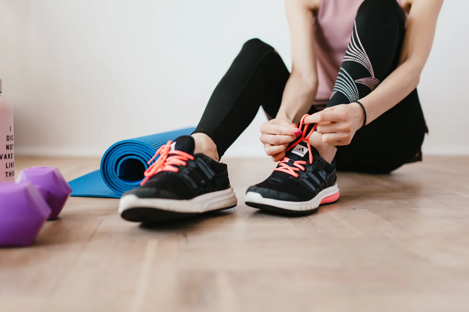 Femme qui lace ses chaussures de sport, prête à se motiver pour sa séance