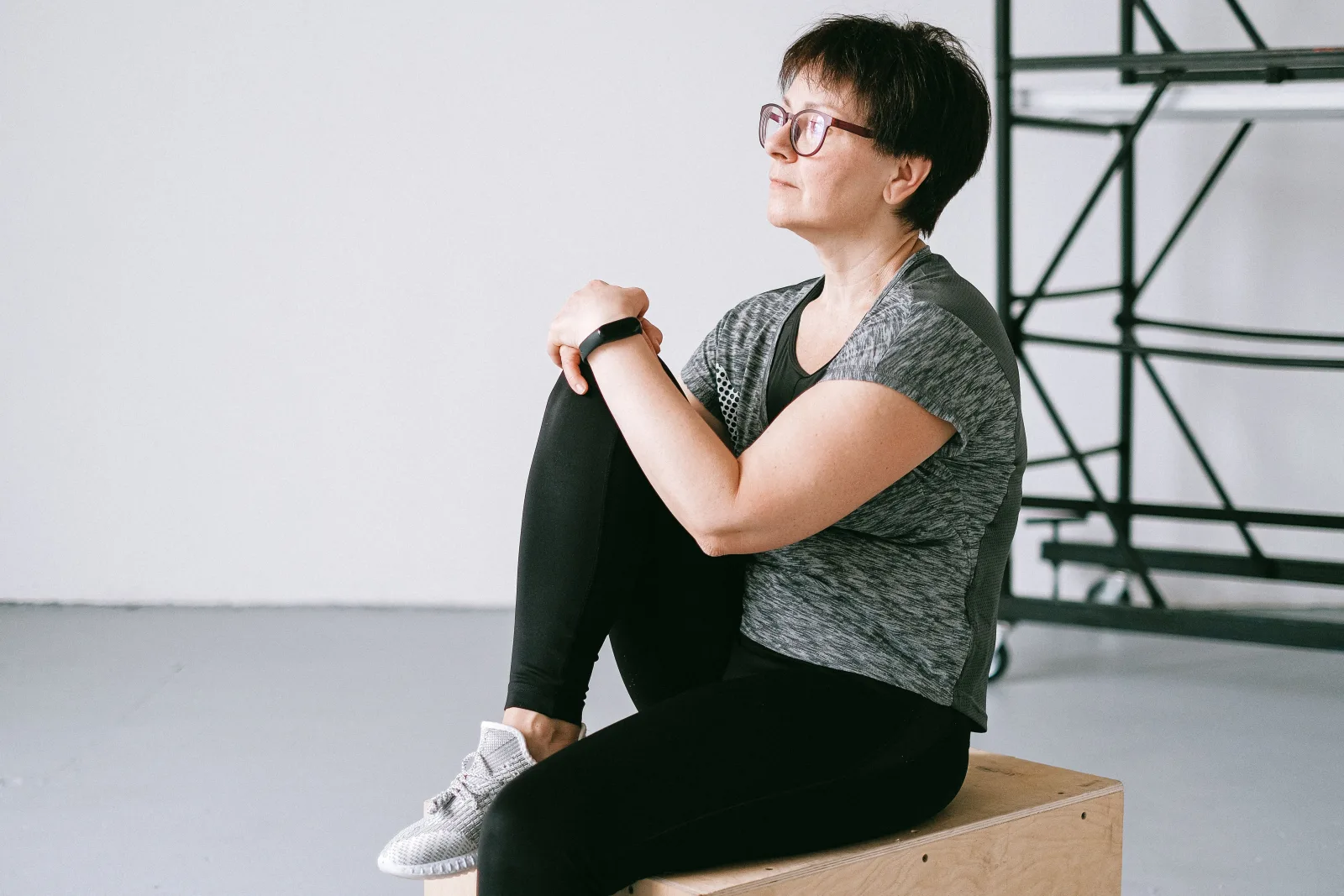 Femme d'une cinquantaine d'années en pause assise entre deux exercices de renforcement
