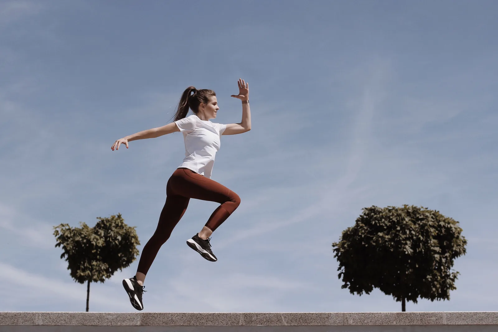 Femme pleine d'énergie qui saute pendant sa séance de sport à la maison