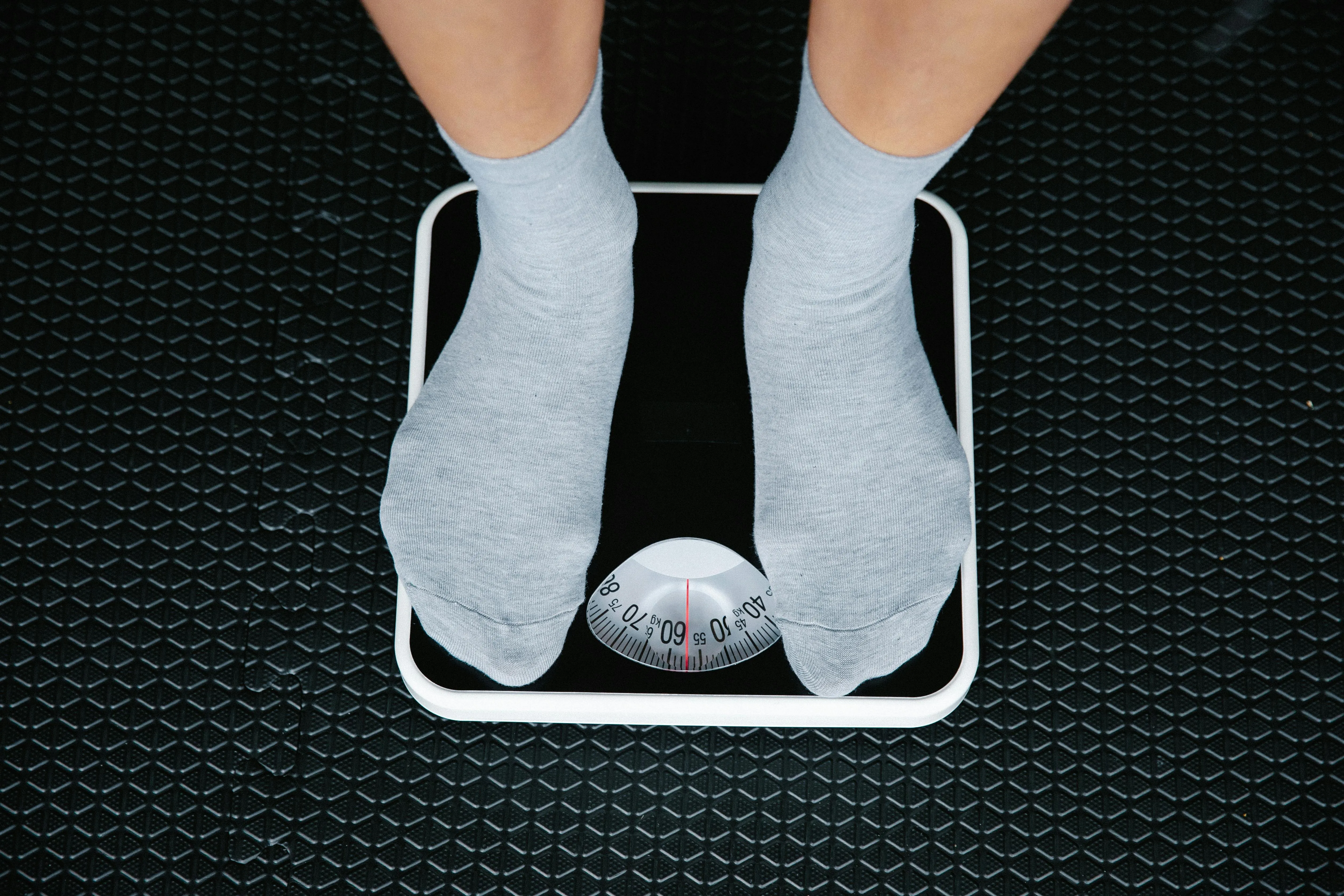 Homme sur une balance - mesurer sa perte de poids