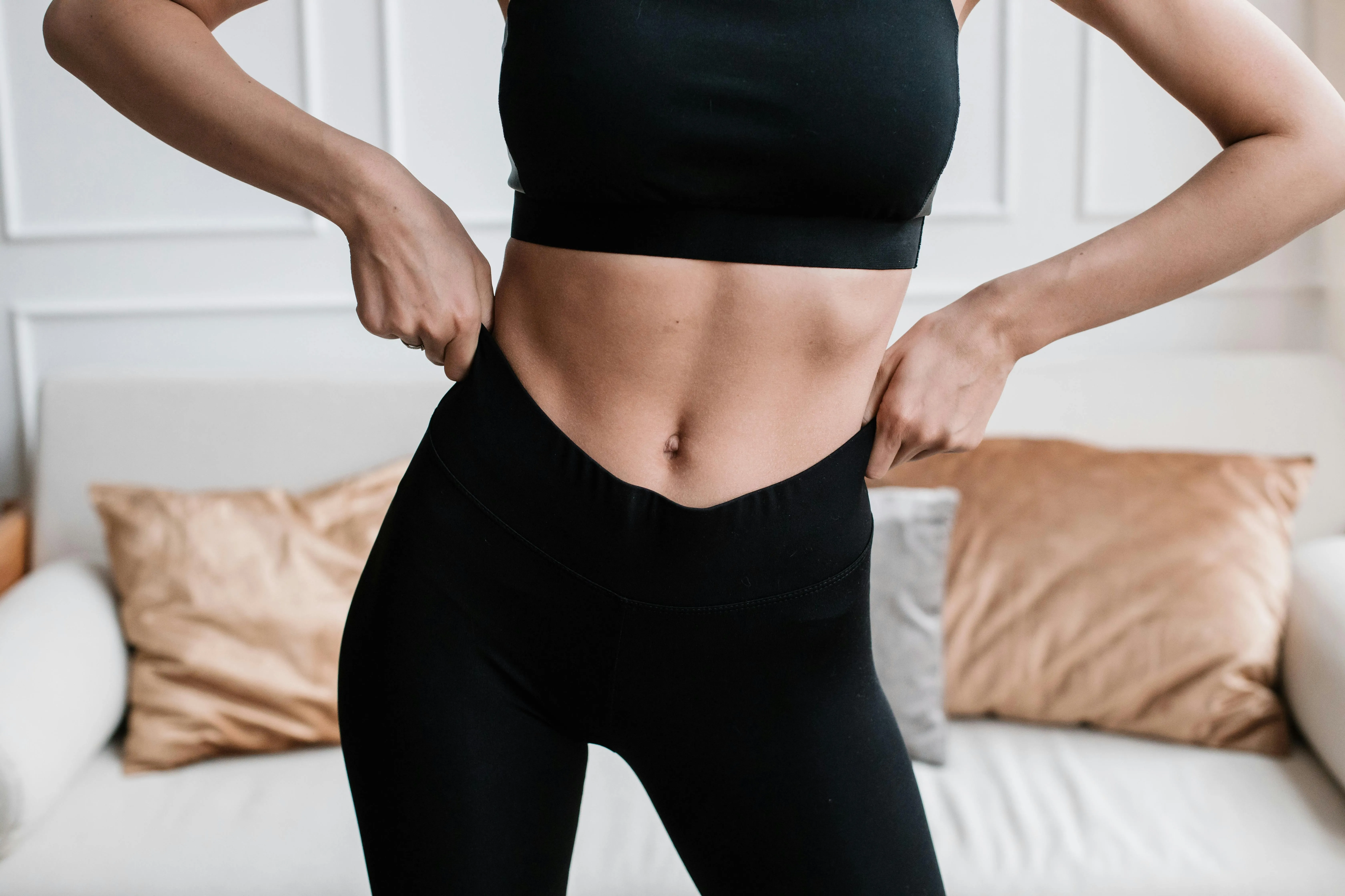 Femme en tenue de sport montrant sa ceinture abdominale - zone du test du doigt pour diastase